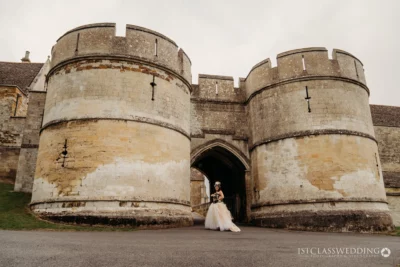 Bride posing at historic castle gateway.