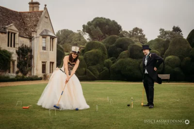 Bride and groom playing croquet at manor house wedding.