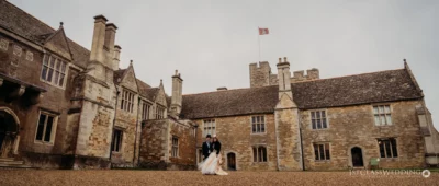 Couple posing at historic stone manor wedding venue.