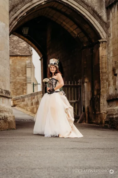 Bride in vintage dress near historical archway.