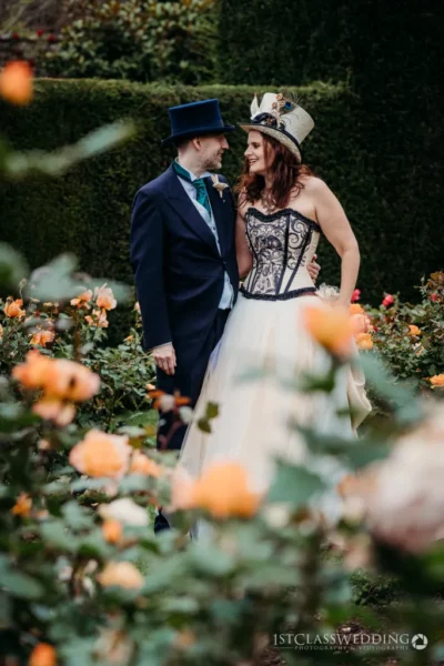 Couple in unique wedding attire among garden roses.