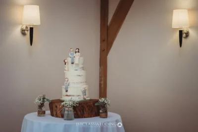Wedding cake with figurine toppers and rustic decorations.