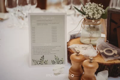 Wedding speech betting game card on elegant table setting.