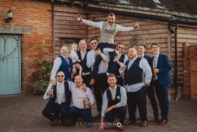 Groomsmen celebrating at a wedding outdoors.