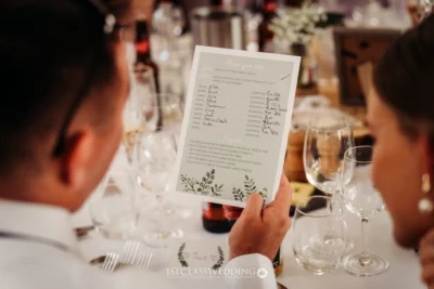 Guests playing wedding speech betting game at table.