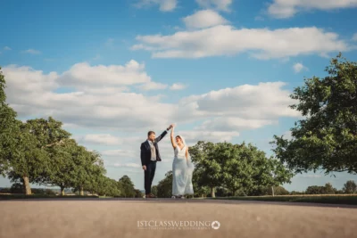 Wedding couple dancing outdoors under blue sky