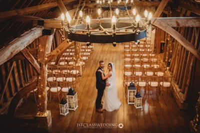 Wedding couple embracing in rustic barn venue.