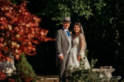 Bride and groom outdoors in sunny autumn wedding setting.