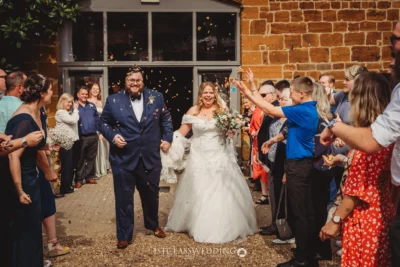 Joyful couple during wedding confetti toss.