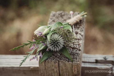 Rustic wedding boutonniere on wooden backdrop.