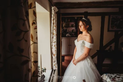 Bride in dress inside vintage room with rustic beams