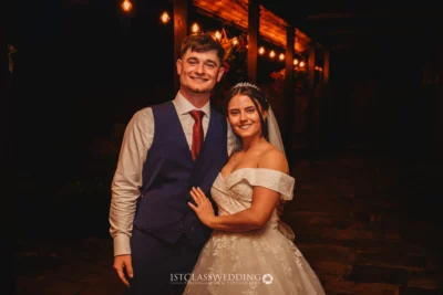 Happy couple posing at night wedding reception.