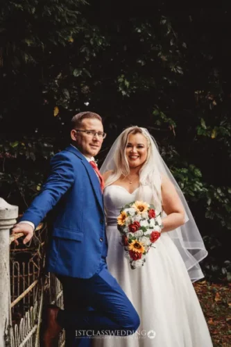 Bride and groom posing with autumnal wedding bouquet