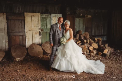 Happy couple posing in rustic wedding attire.