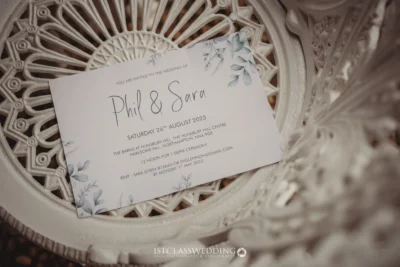Elegant wedding invitation on decorative white ironwork.