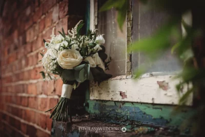 Elegant bridal bouquet by rustic window.
