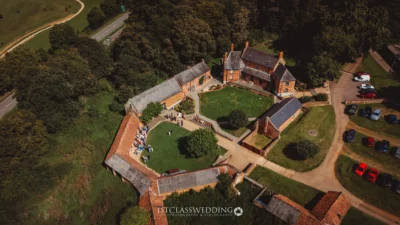 Aerial view of countryside wedding venue with guests.