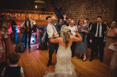 Wedding reception dance with live band and joyful guests.