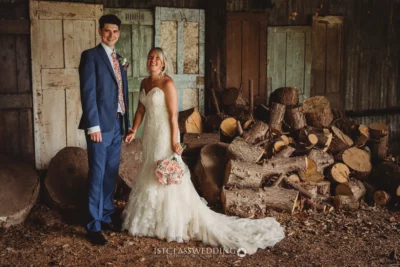 Bride and groom smiling in rustic woodshed setting.
