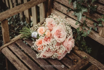 Wedding bouquet on wooden bench.