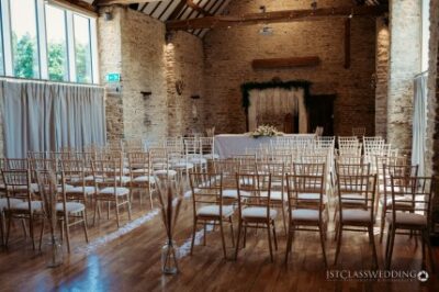 Elegant wedding venue interior with chairs and brick walls.
