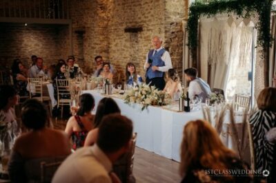 Wedding speech at rustic venue with guests.