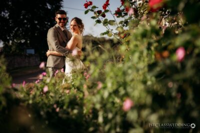 Couple embracing in a garden with blooming roses.