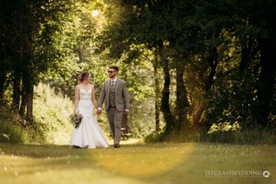 Bride and groom walking in sunlit woods
