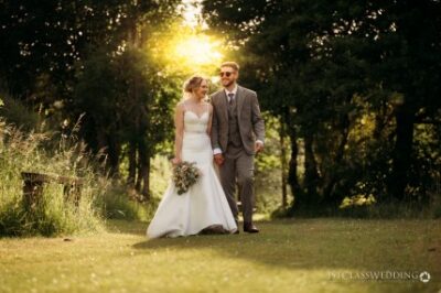 Couple walking in sunset light at woodland wedding