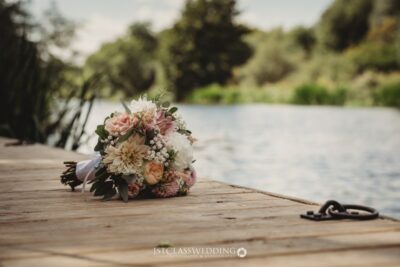 Wedding bouquet on wooden dock by river