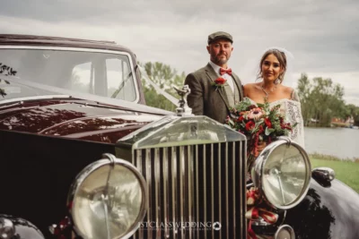 Couple with vintage car at wedding.