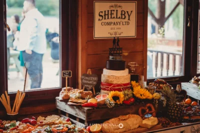 Rustic wedding buffet with cheese wheel cake.