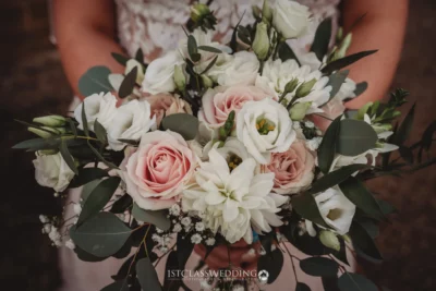 Bride holding a bouquet of pink and white flowers.