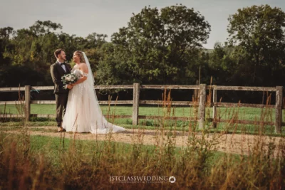Bride and groom embracing in countryside setting