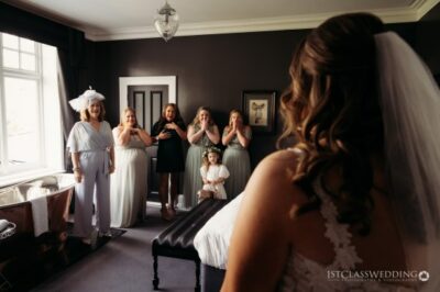 Bride and bridesmaids in elegant attire before wedding ceremony.