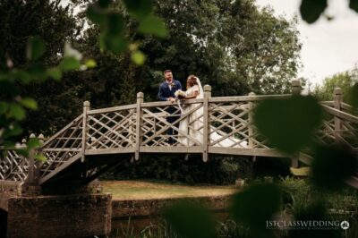 Couple on bridge in serene park setting.