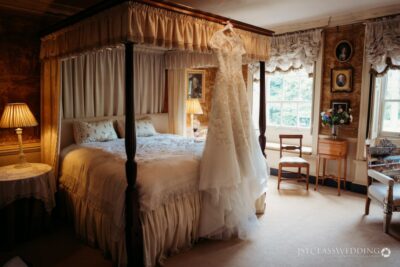 Elegant bridal gown in vintage bedroom setting.