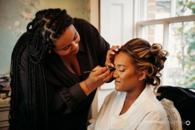 Bridal makeup session in progress with a hairstylist.