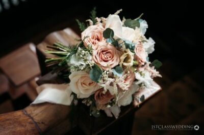 Elegant wedding bouquet on wooden seat.