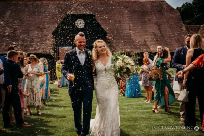 Bride and groom with confetti at rustic wedding.