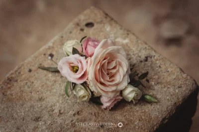 Vintage wedding boutonniere on rustic stone.