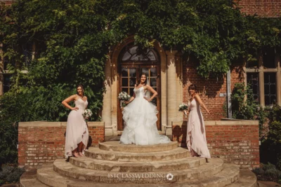 Bride and bridesmaids posing outside historic building.