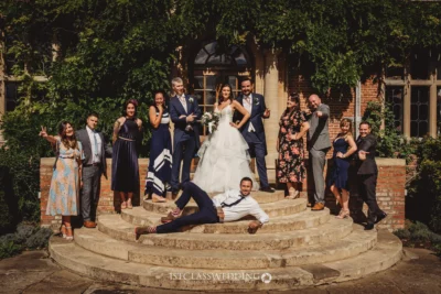 Bridal party posing playfully on sunny steps.