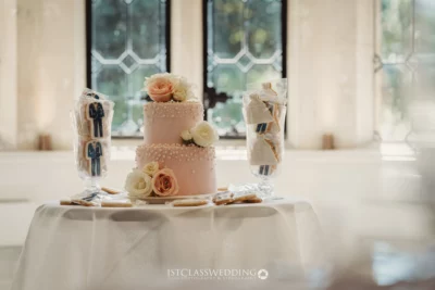 Elegant wedding cake with peach roses on table.