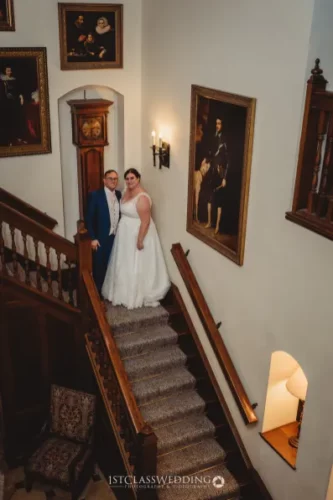 Couple posing on staircase at elegant wedding venue.