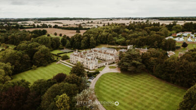 Aerial view of a stately home in a rural landscape.