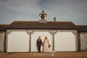 Bride and groom outside traditional building with clock.