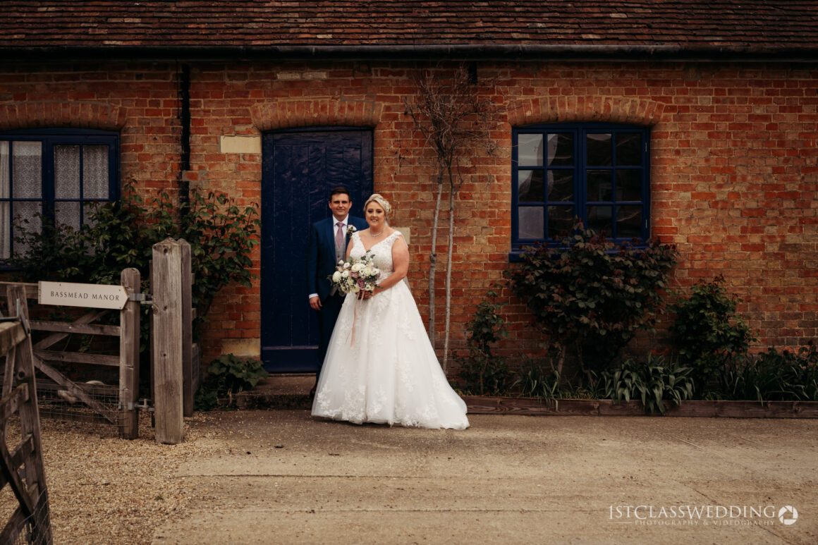 Bride and groom outside historic Bassmead Manor building.