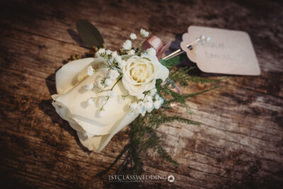 Wedding boutonniere with rose and name tag.