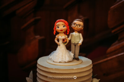 Bride and groom figurines on wedding cake.
